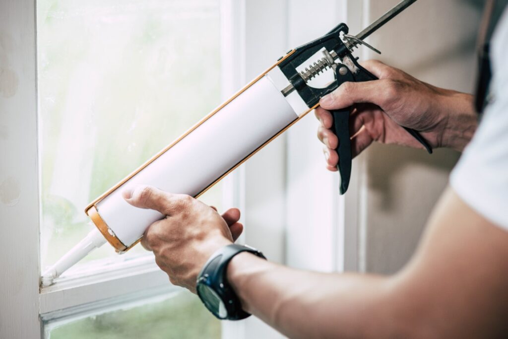 The carpenter holds the glue and attaches to the window.